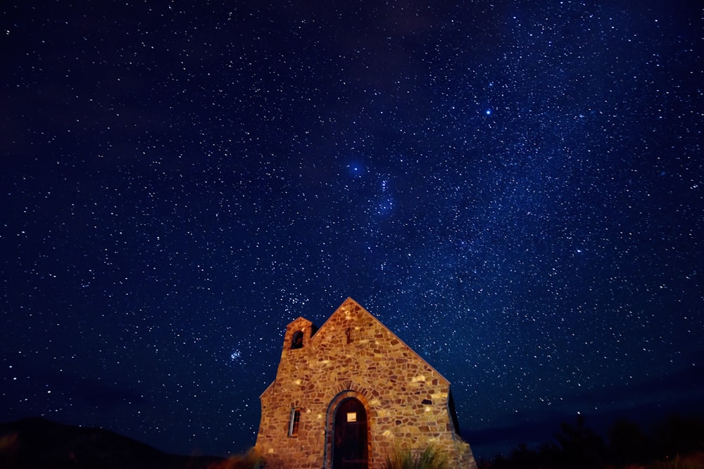 casa di mattoni marroni sotto la notte stellata