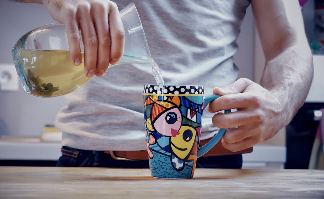 person holding blue and yellow plastic cup