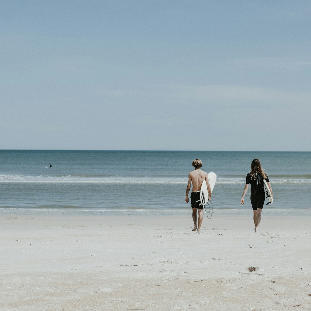 two person walking on coast