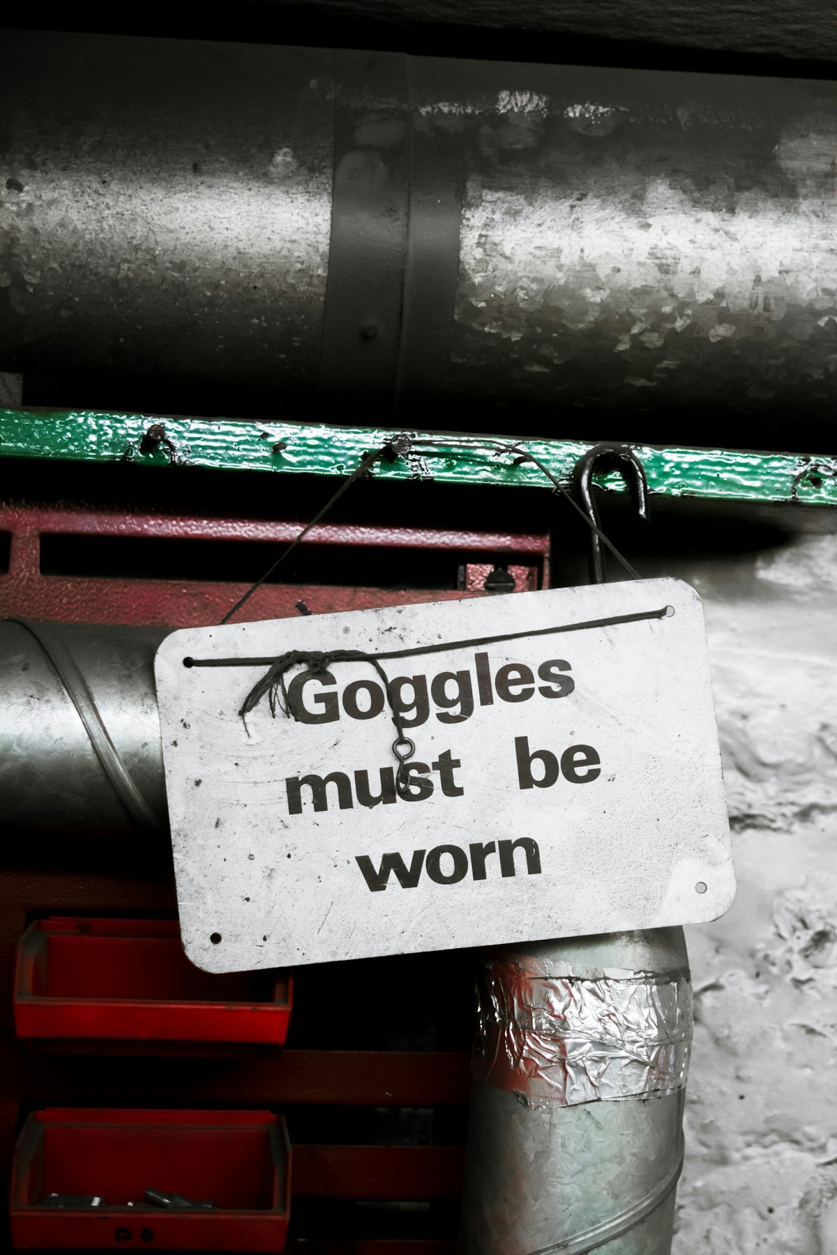 Goggles must be worn(보안경 착용 필수) 문구가 적힌 작업장 안전 표지판