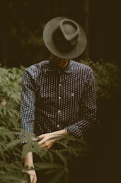 shallow focus photography of man standing while folding his sleeve