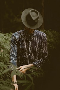 shallow focus photography of man standing while folding his sleeve