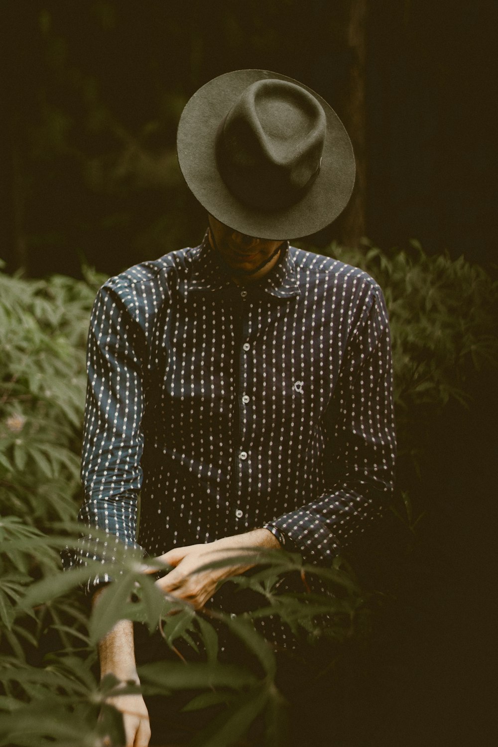 shallow focus photography of man standing while folding his sleeve