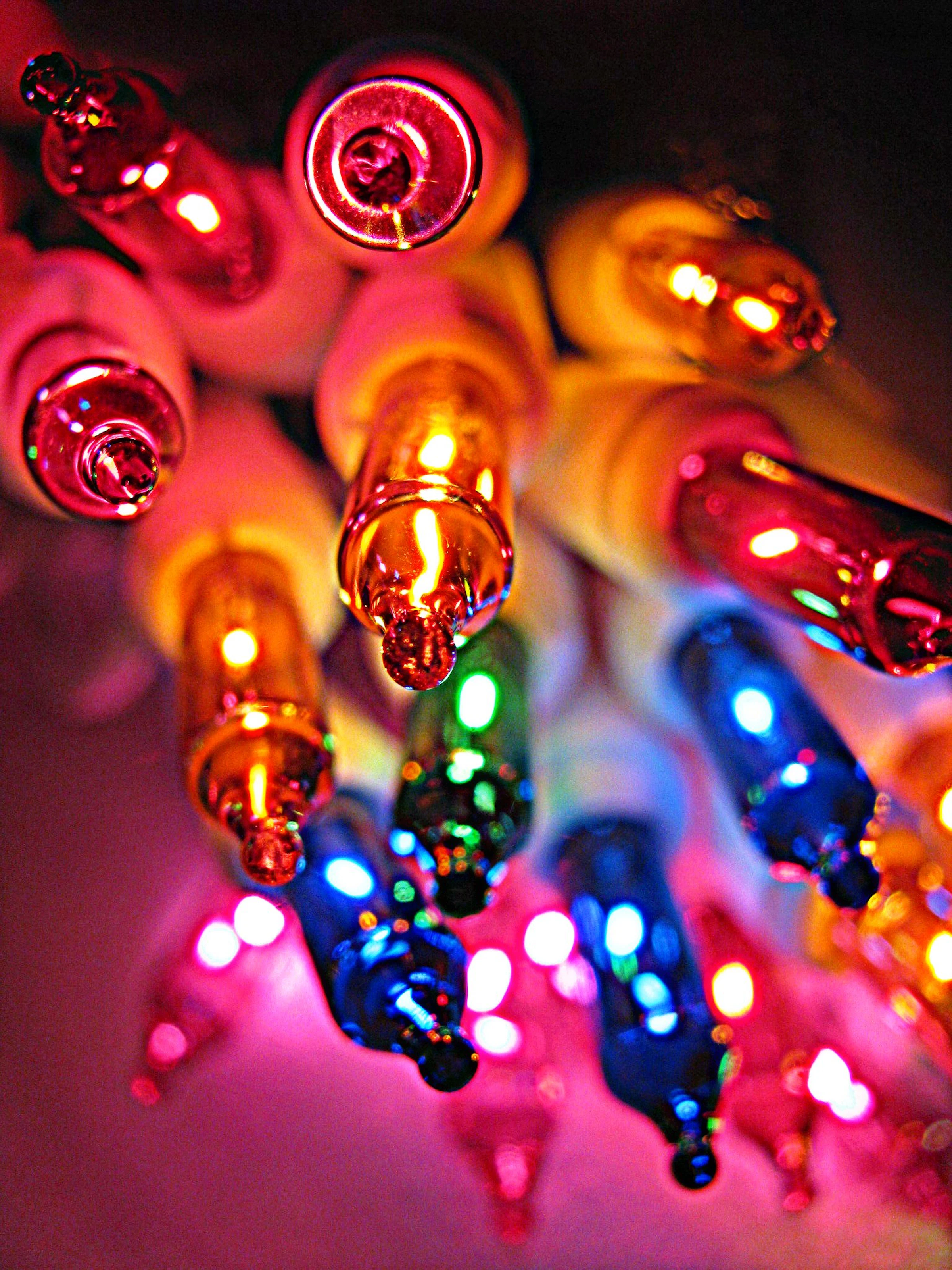 Macro close-up of a cluster of glowing pink, orange, blue, and green miniature light bulbs