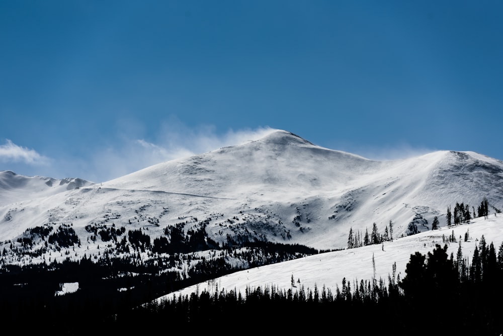 snow capped mountain under blue skies