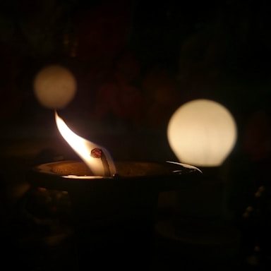 Subtle image of a candle flame glowing softly in a dark room