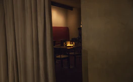 Cozy interior shot featuring dark wood accents, soft champagne lighting, and elegant table settings.