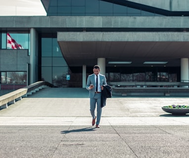 man walking while holding black coat