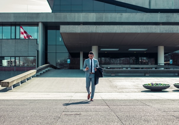 man walking while holding black coat