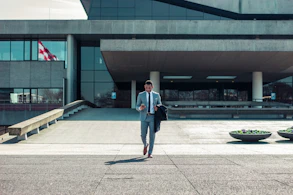 man walking while holding black coat