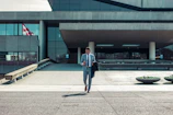 man walking while holding black coat