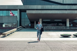man walking while holding black coat