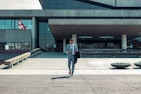 man walking while holding black coat