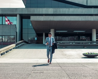 man walking while holding black coat