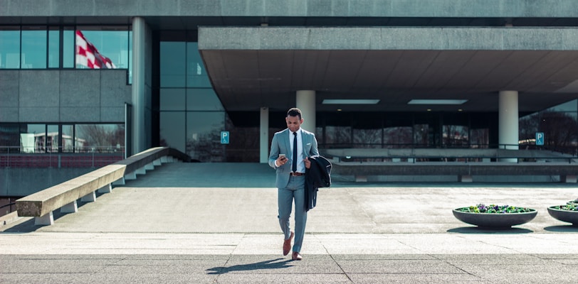 man walking while holding black coat