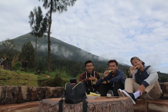 Friends sharing a meal at a cozy local eatery in Kasol, surrounded by lush greenery.