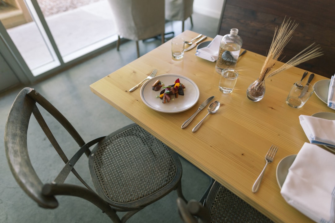 white ceramic plate and silver flatware on table, Trendy Restaurant Table