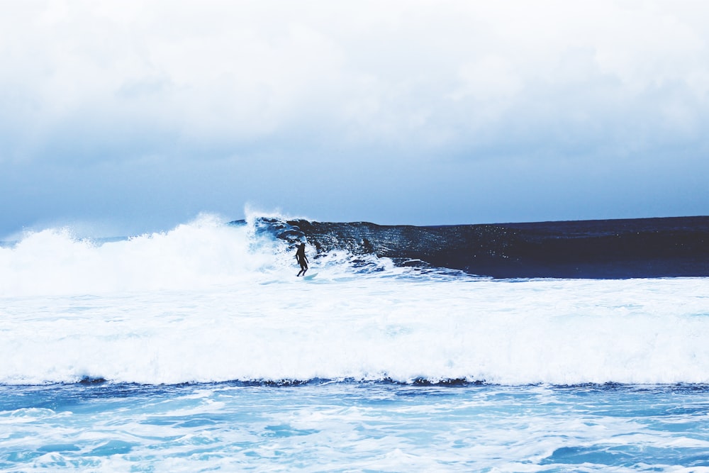 photo of man riding surfboard