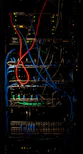 A sleek server rack filled with neatly organized network cables glowing softly in a dimly lit data center.