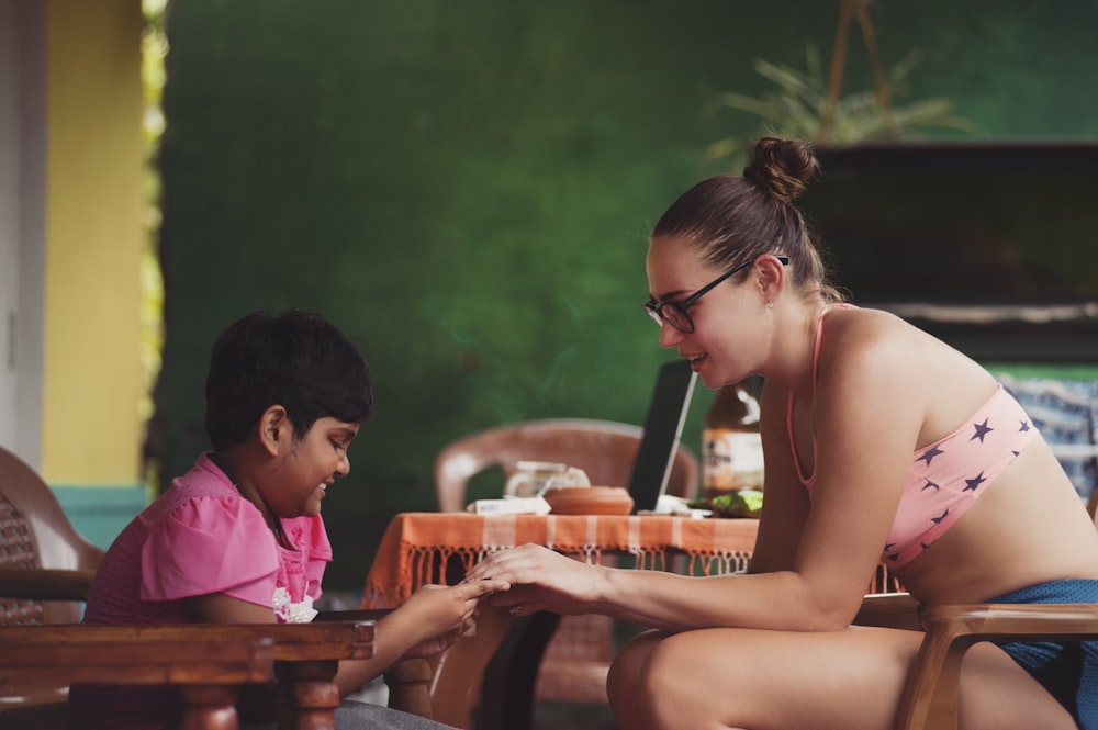 A woman and a child sitting in chairs opposite to each other and playing