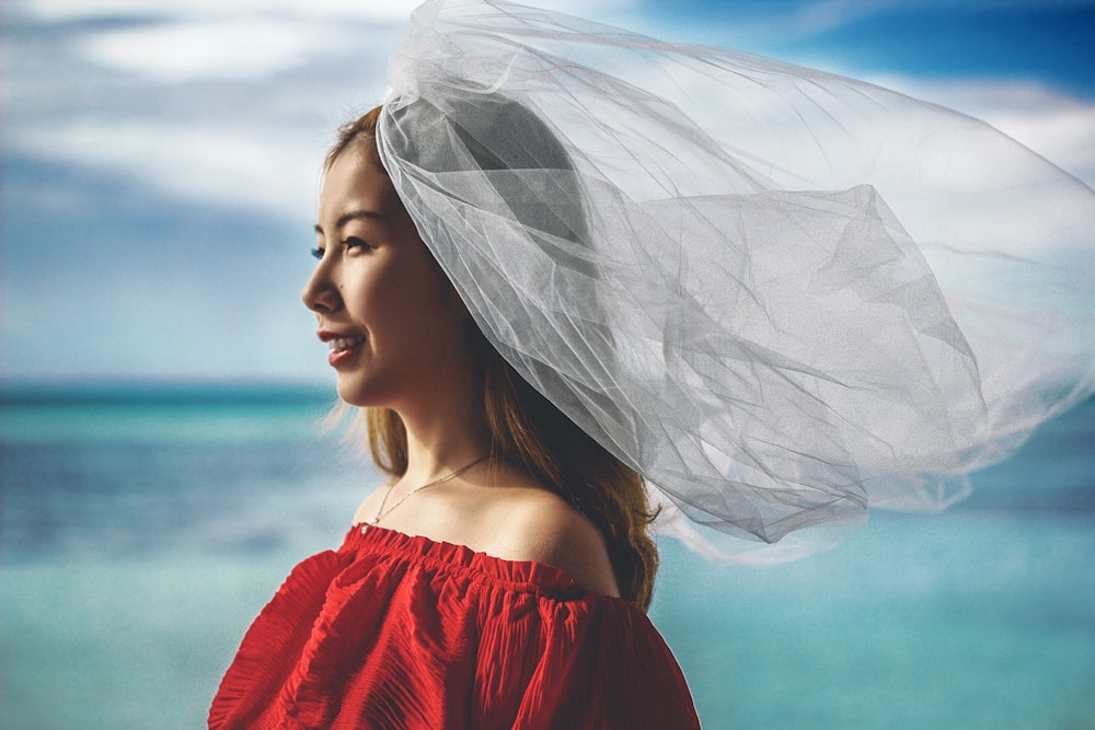 shallow focus photography of smiling woman with body of water background