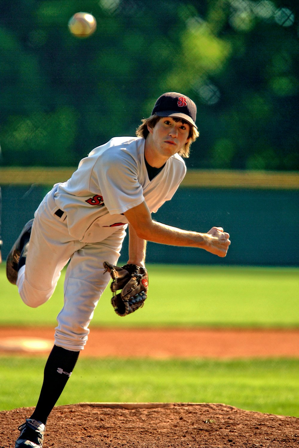 baseball pitcher throwing some fast ball pitch