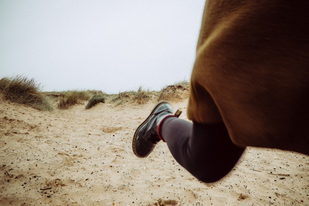 person walking on sandy ground