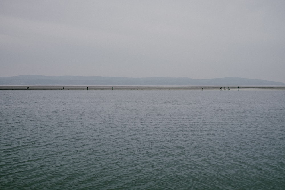 body of water under white sky during daytime