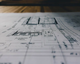 Modern architectural blueprint spread on a sleek desk with technical tools.