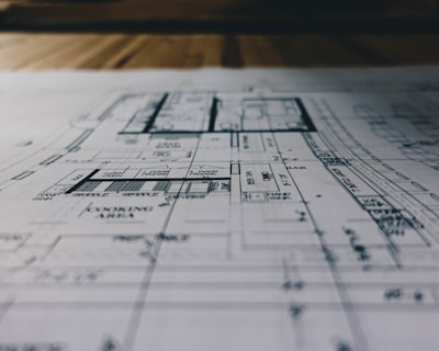 A modern architectural blueprint spread out on a wooden table with design tools.
