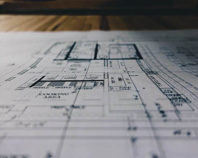 Close-up of colorful printed architectural plans spread on a wooden table