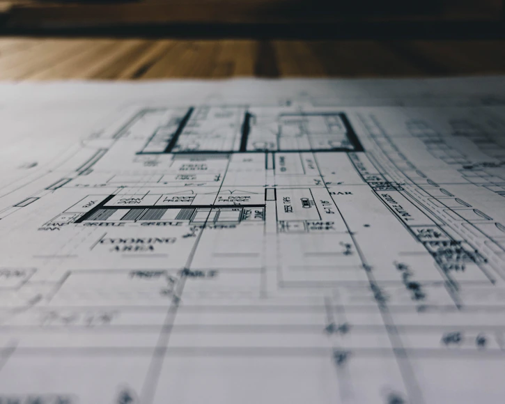 Close-up of detailed architectural blueprints spread out on a drafting table.