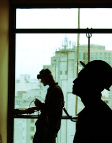 two men wearing hard hat standing near clear glass window