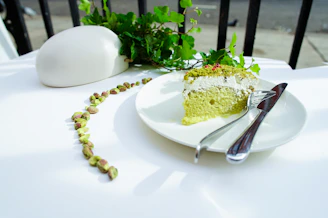 Close-up photo of a rustic pistachio cake with creamy frosting and chopped pistachios sprinkled on top