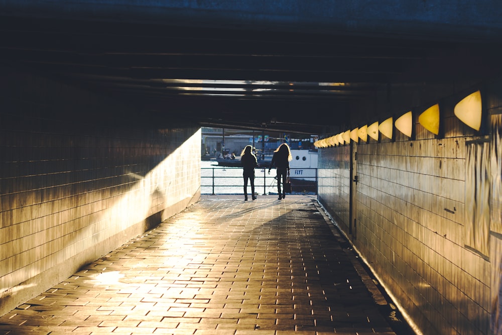 two person walking on hallway