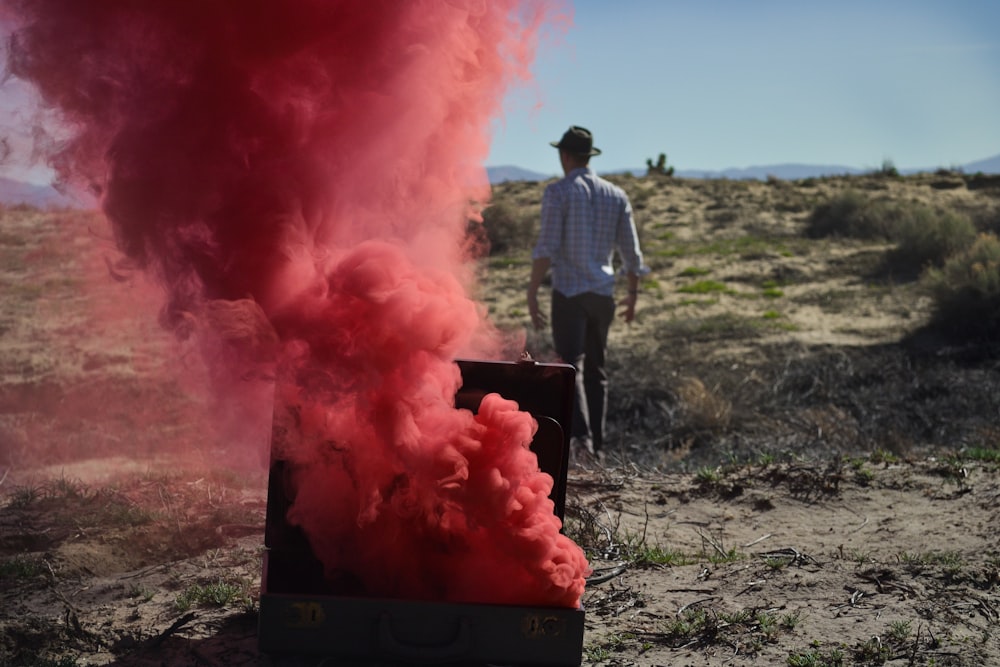 bombe fumigène rouge sur la poitrine près d’un homme portant une casquette noire