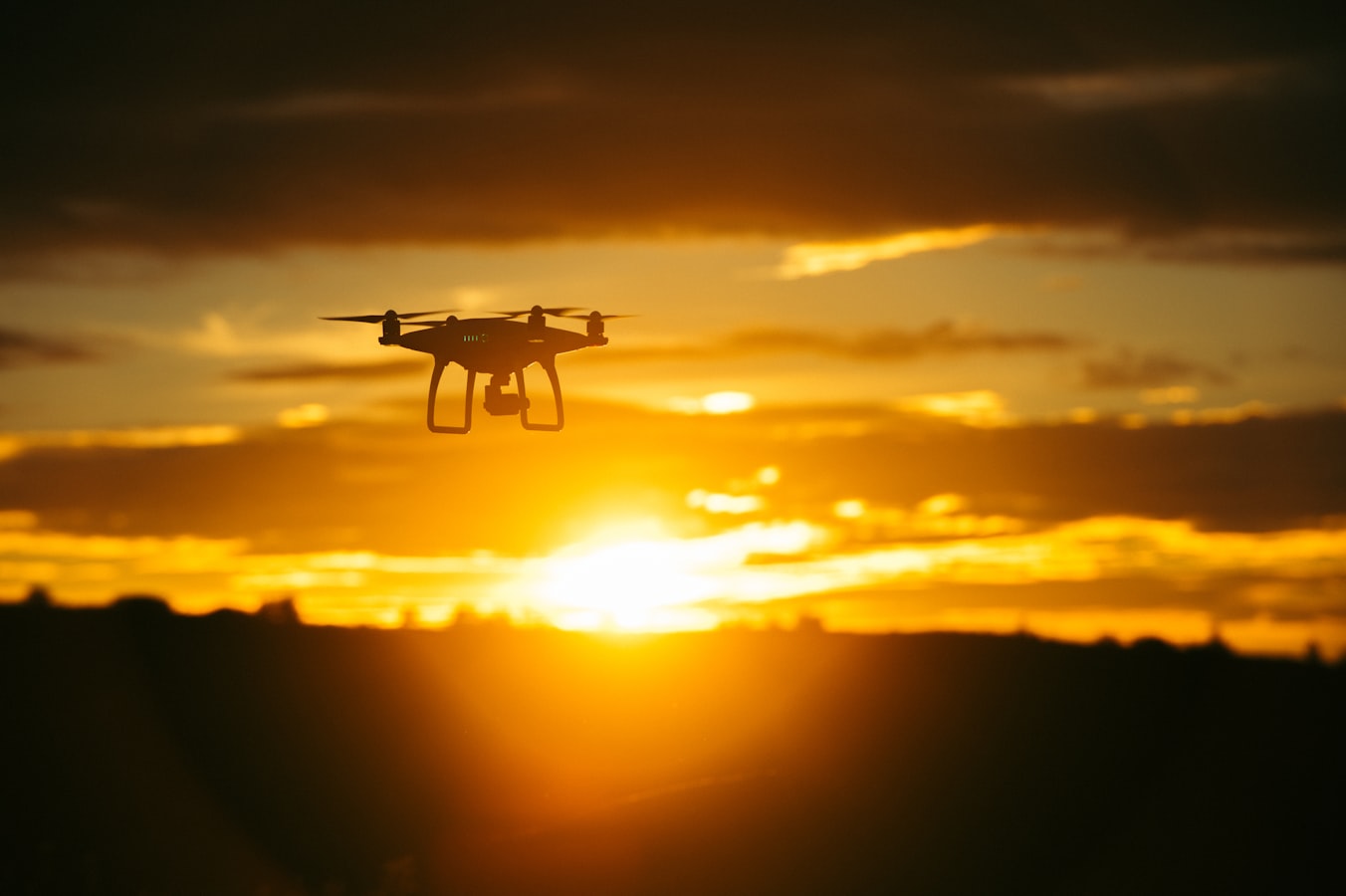 Diep oranje zonsondergang met het silhouet van een drone.