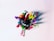 A collection of colorful pens and markers are arranged in a pink container, viewed from above. The items display a variety of colors, including red, green, yellow, blue, orange, and black. The container contrasts against a plain white background, emphasizing the vividness of the pens.
