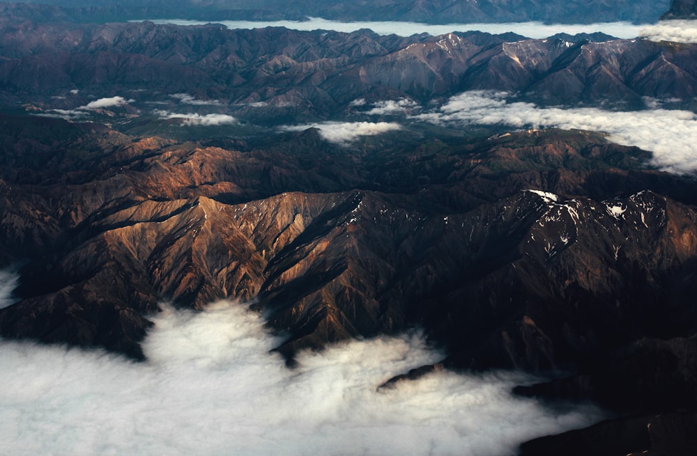 낮에 구름 옆의 갈색 언덕의 항공 사진