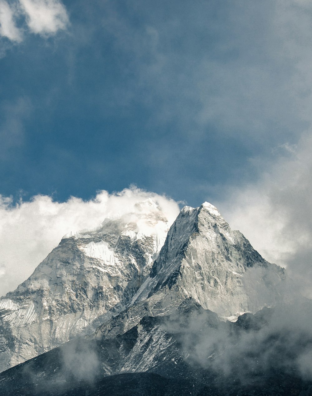 snowy mountain covered by clouds