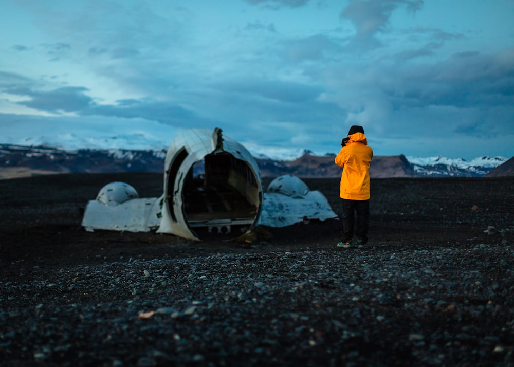 person standing on abandoned plane under white clouds