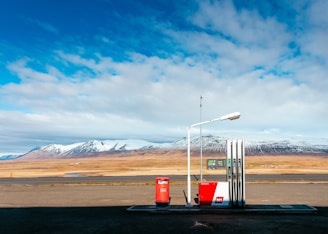 empty gas station near empty road facing snow capped mountain at daytime