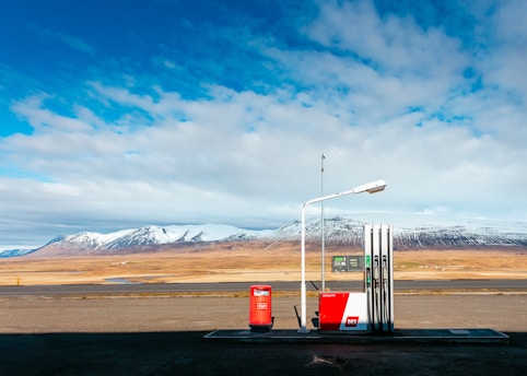 empty gas station near empty road facing snow capped mountain at daytime