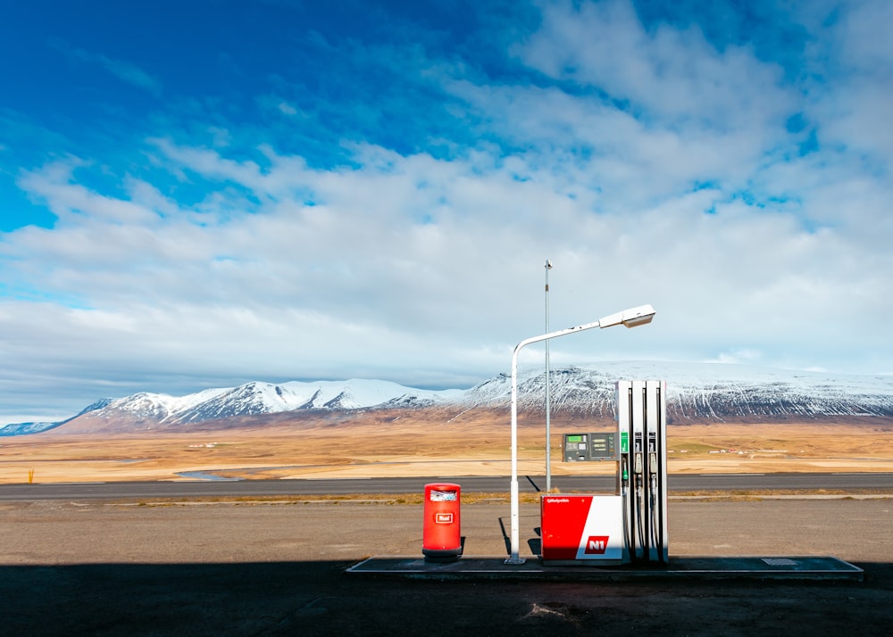 Leere Tankstelle in der Nähe der leeren Straße mit Blick auf den schneebedeckten Berg am Tag
