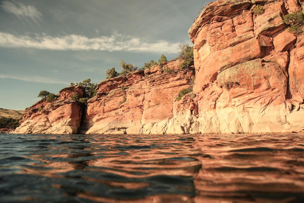 brown rock formation near body of water during daytime