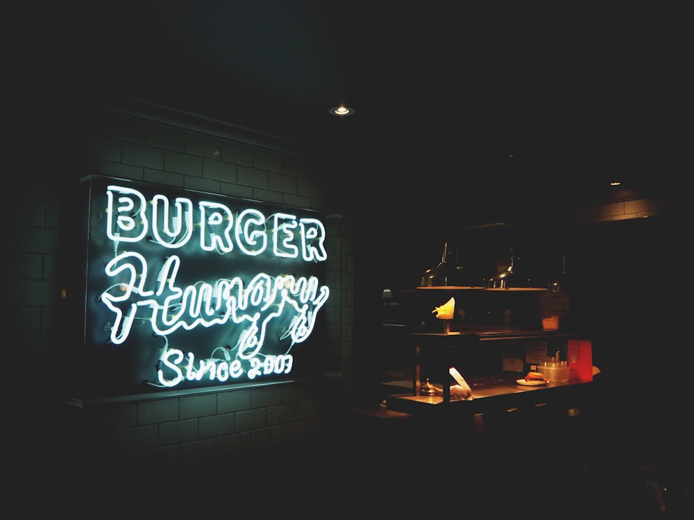 Letrero de neón de Burger Hungry montado en la pared pintada de blanco