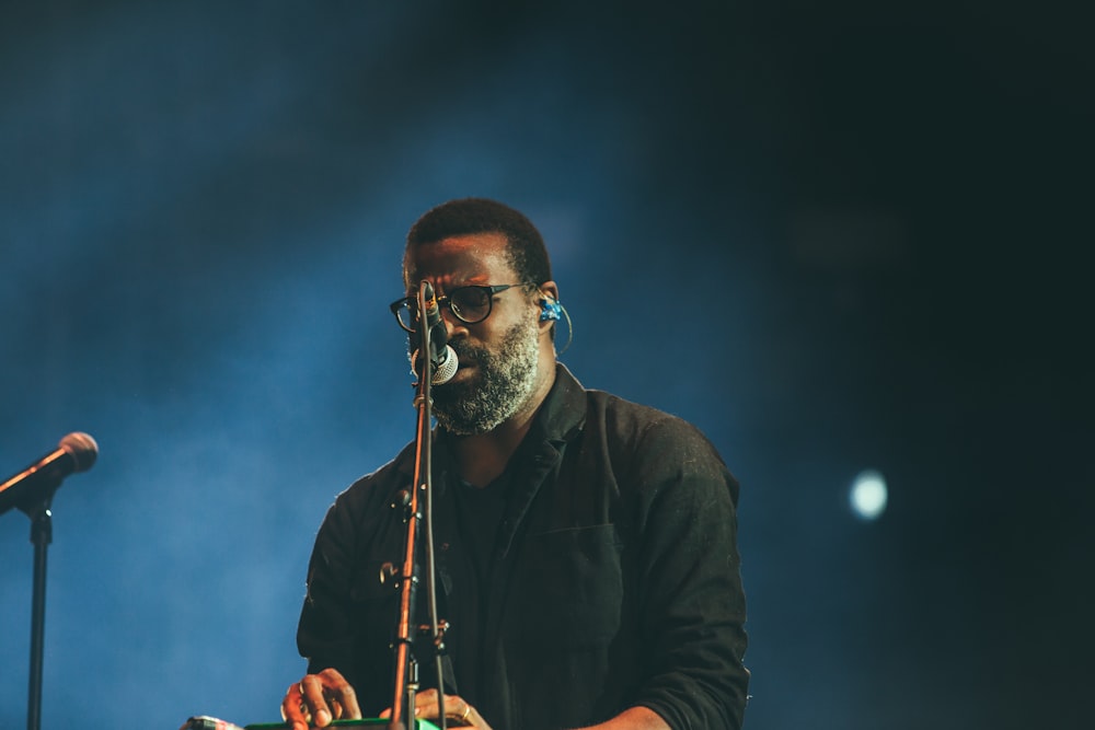 man standing facing microphone