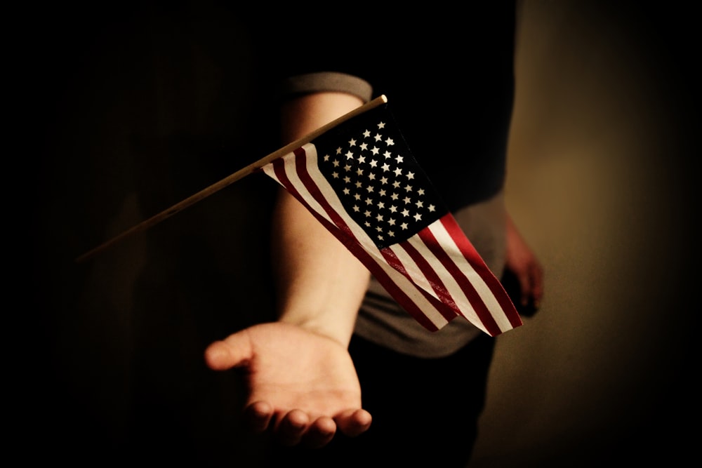 person with open palms below USA flaglet