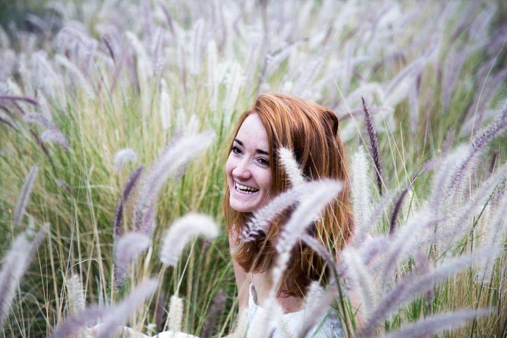 femme assise sur le champ d’herbe