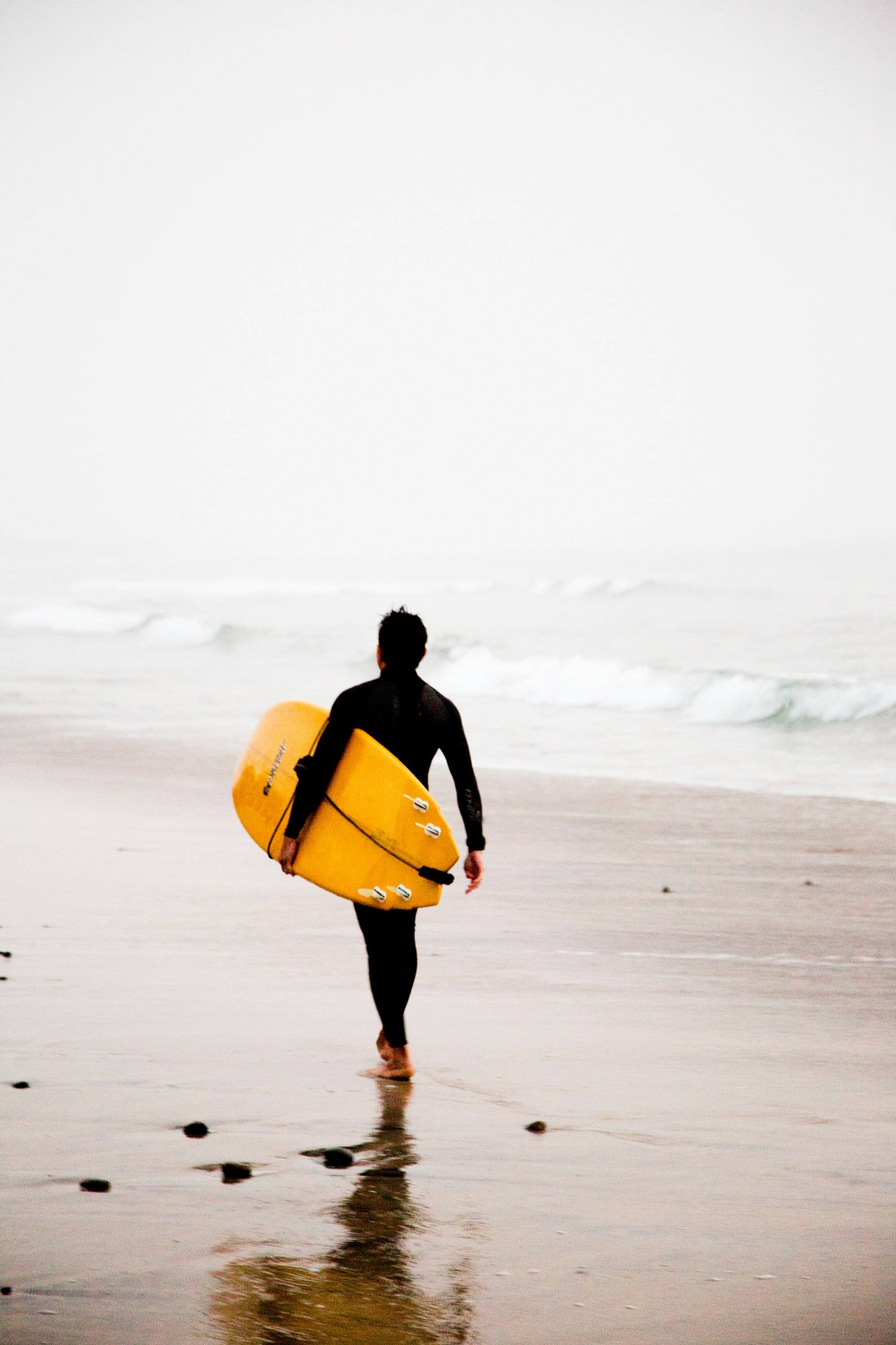 Surfer heading towards the sea
